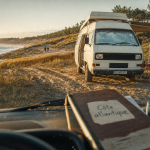 Road trip sur la côte atlantique : van aménagé près des dunes et mer Atlantique