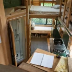 Intérieur tiny house 4 personnes en bois, 2 mezzanines et couchages permanents